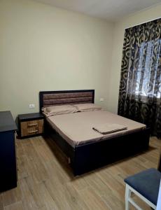a bedroom with a bed and a dresser and a window at Fabio's house in Pogradec