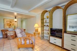 a living room with a television and a chair and a table at 50 Feet to Ocean Kona Deluxe Ground-Floor Unit! in Kailua-Kona