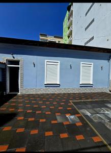 a blue building with two windows and a checkered floor at Fabio's house in Pogradec +8 photos