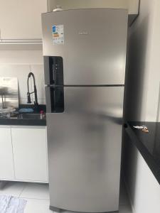 a stainless steel refrigerator in a kitchen with white cabinets at Condomínio vivendas do Rio 2 in Ananindeua