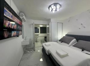 a bedroom with a large white bed and a bathroom at GALAXY - Futuristic apartment SPLIT in Split