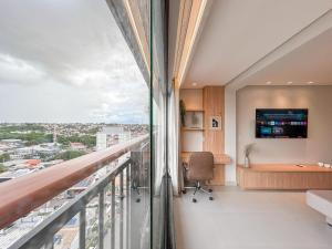 una oficina con balcón y escritorio en Flat Relicário com Linda Vista da Cidade, en Campo Grande