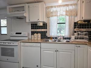 a kitchen with white cabinets and a sink at Imma Place in Trenton