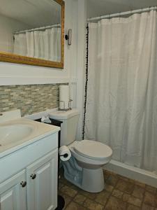 a bathroom with a white toilet and a sink at Imma Place in Trenton