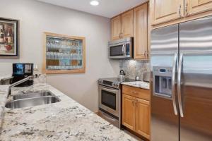 a kitchen with stainless steel appliances and wooden cabinets at Lodge Tower 778 Two Bedroom Residence in Vail
