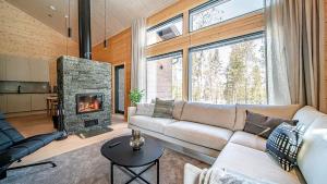 Una sala de estar con un sofá y una chimenea. en Villa Velho, en Äkäslompolo 22 fotos más