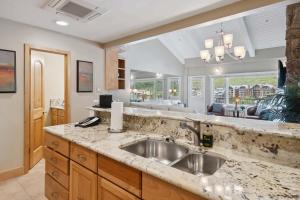 a kitchen with a sink and a living room at Lodge Tower 778 Two Bedroom Residence in Vail +16 photos