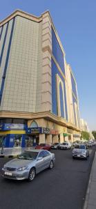 a large building with cars parked in front of it at Mina Concorde Hotel in Makkah