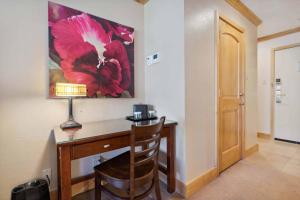 a desk with a lamp and a red flower painting on the wall at Lodge Tower 782 in Vail