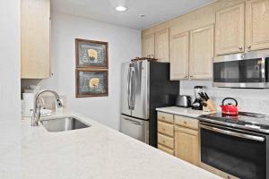 a kitchen with a stainless steel refrigerator and a sink at Lodge Tower 786 Two Bedroom Residence in Vail