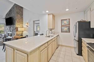 a kitchen with a sink and a refrigerator at Lodge Tower 786 Two Bedroom Residence in Vail