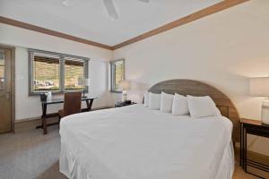 a bedroom with a large white bed and a desk at Lodge Tower 786 Two Bedroom Residence in Vail