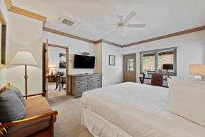 a bedroom with a white bed and a television at Lodge Tower 786 Two Bedroom Residence in Vail +17 photos