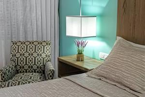 una camera da letto con un letto, una sedia e un tavolo di Departamento de Lujo a Pasos de 5ta Avenida 208S a Playa del Carmen