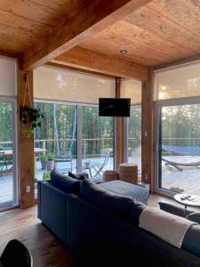 a living room with a couch and a flat screen tv at Slow Living Lodge- SPA - Pet friendly in Saint Come