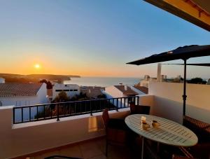 een balkon met een tafel en uitzicht op de oceaan bij Casa Calma in Salema