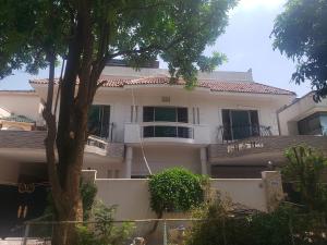 una casa blanca con un árbol delante en Guest Ghar Islamabad, en Islamabad