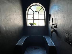 una habitación oscura con una ventana y una bañera en Luxury Beach Front Boutique Hideaway with Pool - Casita Mas Tranquila, en Conil de la Frontera