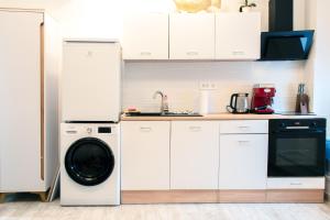 a white kitchen with a washing machine in it at Six Lamps on Masarykova in Zagreb