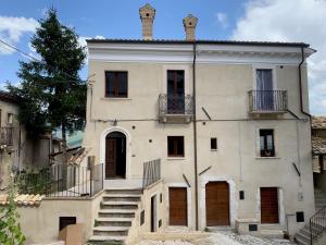 a large white building with stairs in front of it at Casa Gagliano Aterno in Gagliano Aterno
