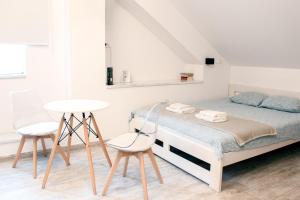 a bedroom with a bed with two chairs and a table at Six Lamps on Masarykova in Zagreb
