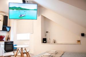 a living room with a tv hanging on the wall at Six Lamps on Masarykova in Zagreb