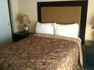 ラスベガスにあるジョッキー リゾート スイーツ センター ストリップのランプ付きの客室の大型ベッド1台