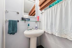 a white bathroom with a sink and a mirror at Bay & Birch Getaway - Lakefront Living in Wiarton