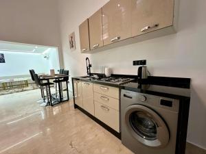 a kitchen with a washing machine next to a table at Chic duplex luxury3suites et wi-fi in Marrakech