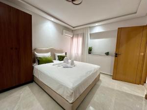 a bedroom with a large white bed with green pillows at Chic duplex luxury3suites et wi-fi in Marrakech