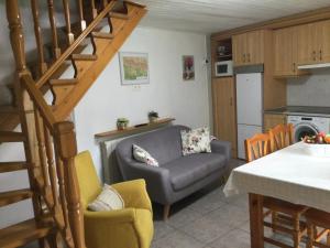 a living room with a couch and a kitchen at La Casita de Ordesa in Frajén
