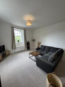 una sala de estar con un sofá y una mesa en Glyder Flat - North Wales, en Dolgellau