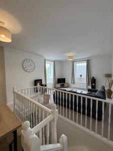 Sala de estar con escalera y reloj en la pared en Glyder Flat - North Wales, en Dolgellau 10 fotos más