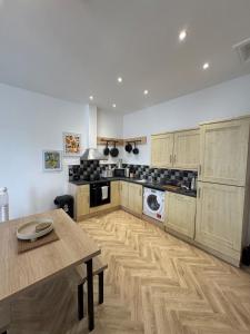 Una cocina con gabinetes de madera y una mesa en ella. en Glyder Flat - North Wales, en Dolgellau
