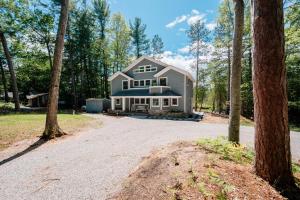 a large house with trees in front of a driveway at After Dune Delight, 5BR Home Near River in Glen Arbor