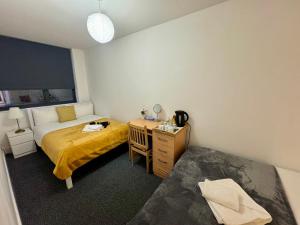 a bedroom with a bed and a desk and a bed and a table at Modern Private Bedrooms in Euston 2 in London +13 photos