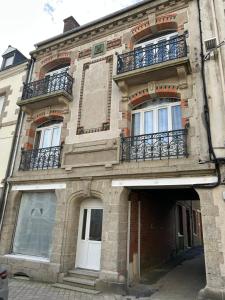 a large building with a door and balconies on it at L'Authentique - Appartement 6 in Loudéac