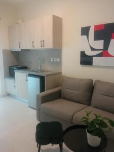 a living room with a couch and a table and a kitchen at Line & Light in Ioannina