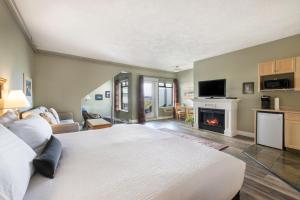 a bedroom with a large bed and a fireplace at Sidney Waterfront Inn & Suites in Sidney