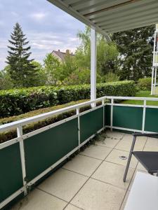 a fence on a porch with a table and a chair at Attraktive 3ZKB-Wohnung zentrumsnah in Wolfenbüttel