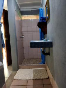 a bathroom with a shower with a blue sink at Hostal Xilotl in San José del Sur +107 photos