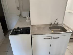 a small kitchen with a sink and a stove at Eco Dpto Estudio El golf 9 in Santiago