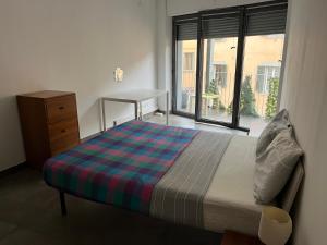 ein Schlafzimmer mit einem Bett, einer Kommode und einem Fenster in der Unterkunft Barattularia House in Pisa