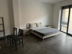 ein Schlafzimmer mit einem Bett und einem Tisch und Stühlen in der Unterkunft Barattularia House in Pisa