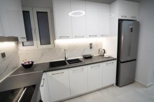a white kitchen with a sink and a refrigerator at Luxury Apartment in Lamia in Lamía