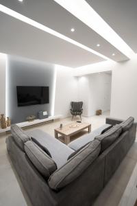 a living room with a large couch and a tv at Luxury Apartment in Lamia in Lamía