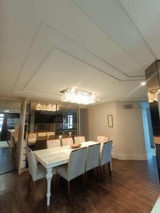 a dining room with a white table and chairs at Deluxe apartment com 4 suítes no coração da grande Florianópolis in São José