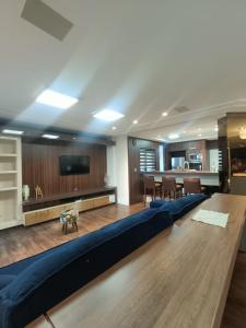 a living room with a large couch and a table at Deluxe apartment com 4 suítes no coração da grande Florianópolis in São José