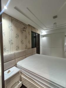 a bedroom with a large white bed in it at Deluxe apartment com 4 suítes no coração da grande Florianópolis in São José