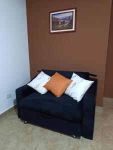a blue couch with two pillows on top of it at Hospedaje Las Rosas in La Quiaca